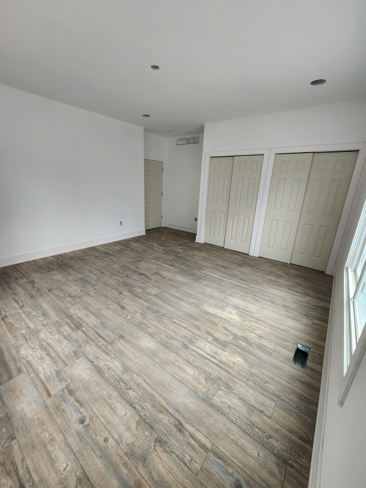 Interior luxury vinyl plank flooring installation bedroom 2000 sq feet whole home remodel — completed by 848 Property Services in Hastings, MI.