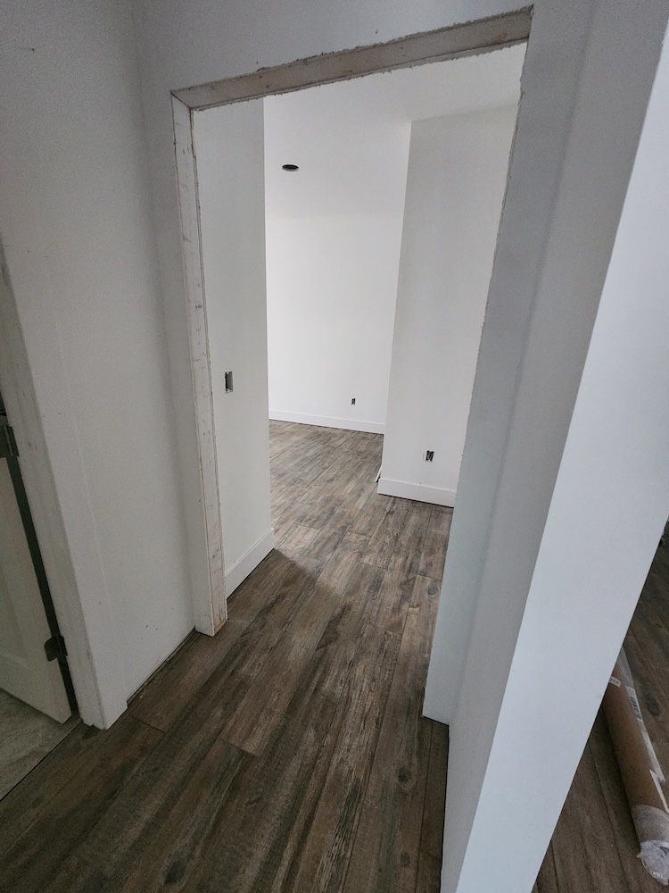 Interior luxury vinyl plank flooring installation hallway 2000 sq feet whole home remodel — completed by 848 Property Services in Hastings, MI.
